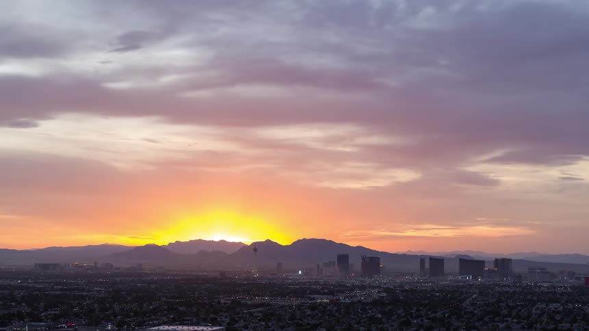 A sunset with a strong yellow light on the horizon in a large city