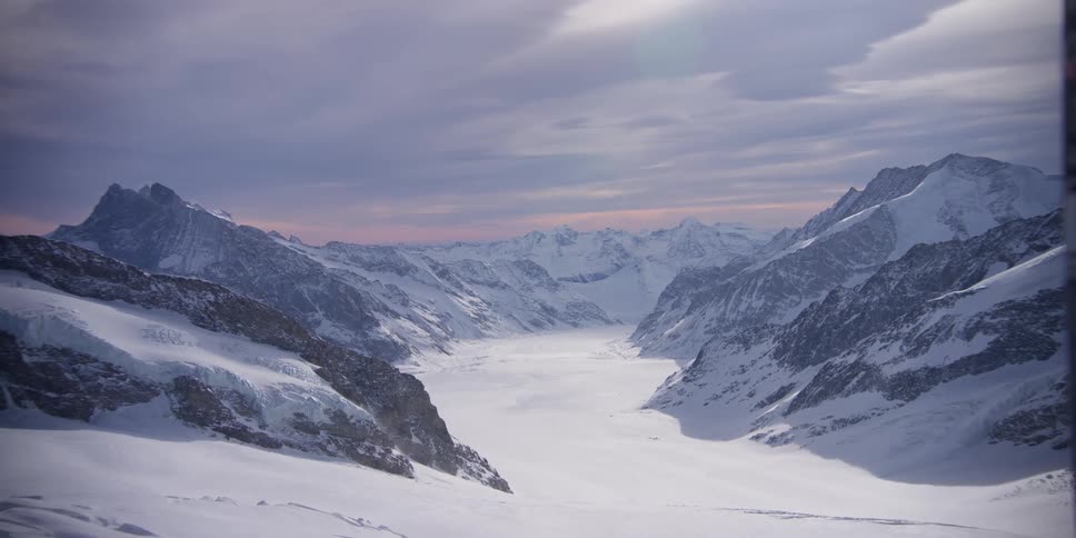 Mountain range covered by snow on a cloudy day in a morning sky