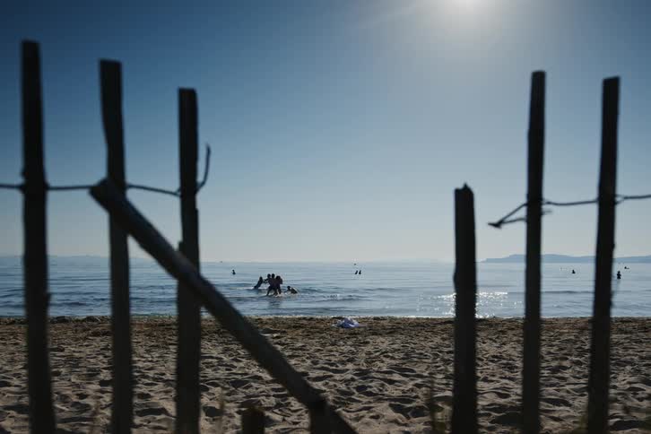 A group of friends playing at the beach and in the ocean