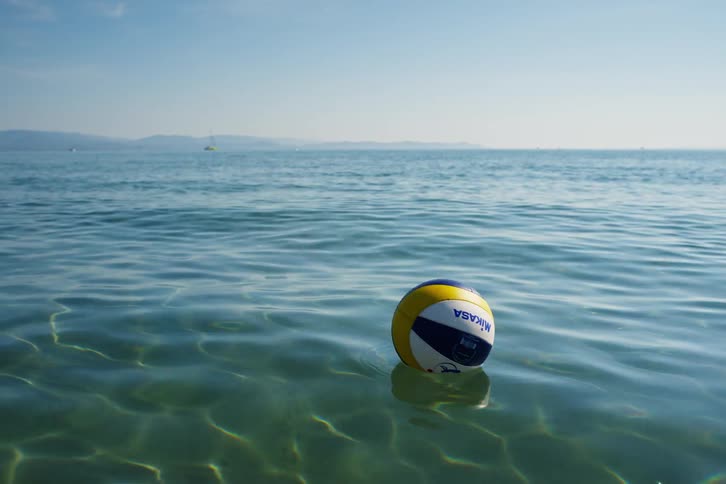 Colorful ball floats on ocean surface with the misty shore in the distance
