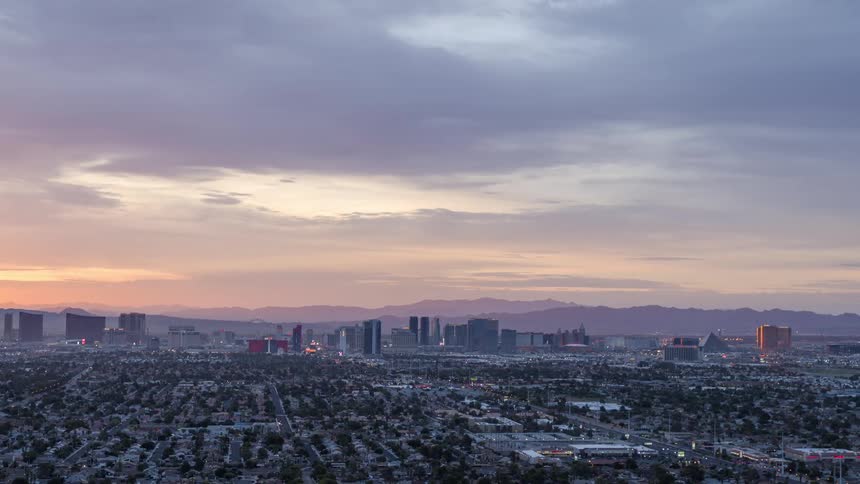 Aerial of suburbs and a distant metropolis at sunrise