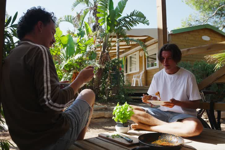 Two guys share a meal on a patio