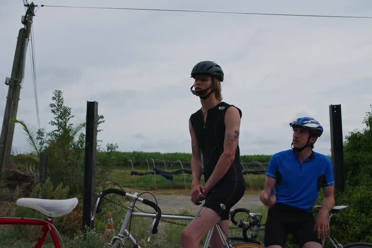 Young men on bicycles discuss their plans before leaving
