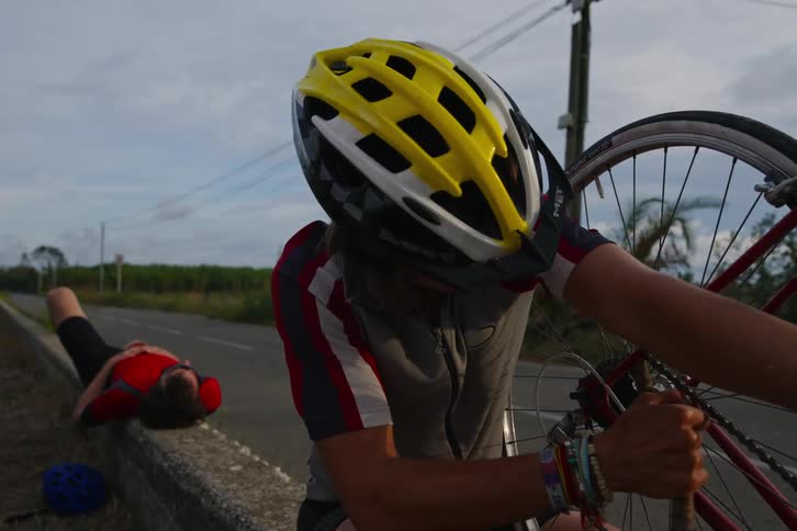 Man fixing his bike and next to his cycling friends talking
