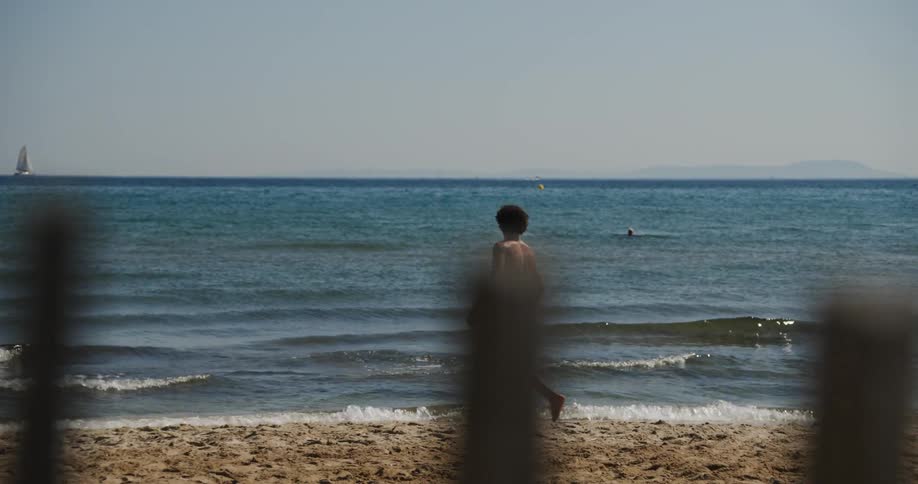 A man dancing out at the beach near the shoreline