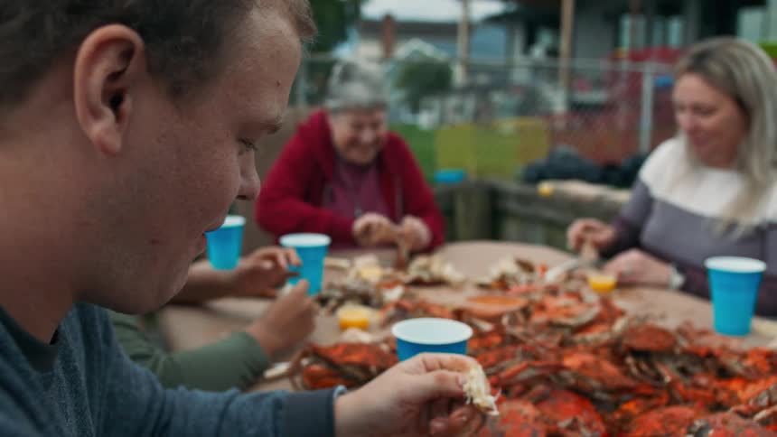 People sitting at a table eating crab