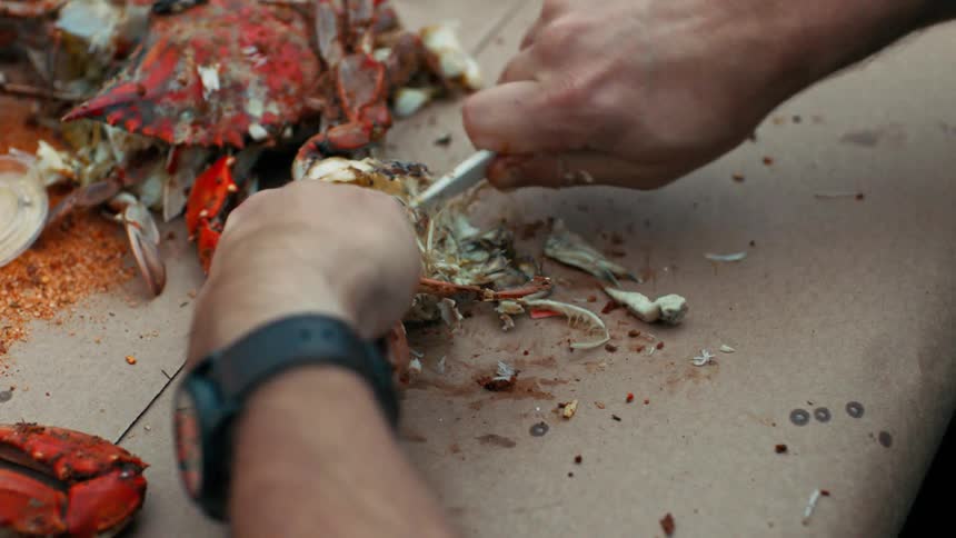 A man cuts into a crab at a restaurant