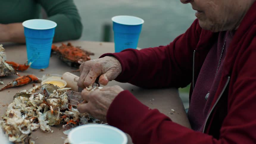 A person breaking open crab legs to eat them