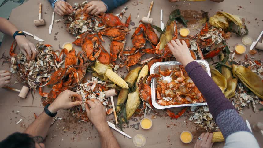 Four people eat seafood at an outdoor restaurant