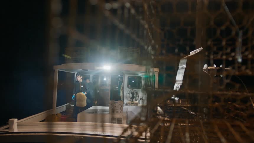 Two men inside a fishing boat at night