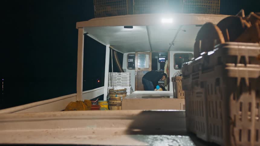 Man inside a fishing boat at night