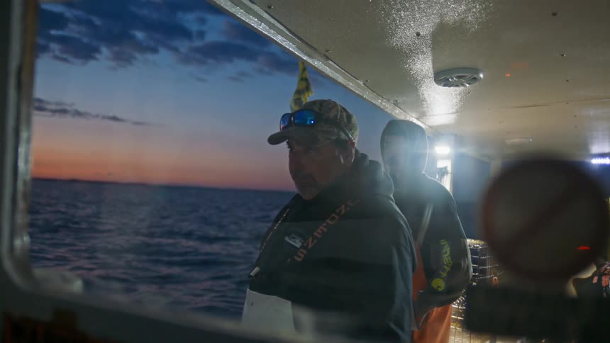 Three men talking on a fishing boat