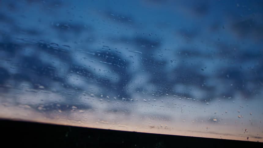 Window of a boat overlooking the reddish and bluish morning sky