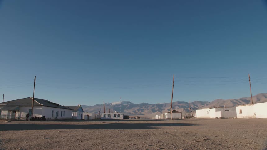 A small neighborhood in a rural sandy area at the base of a mountainous region