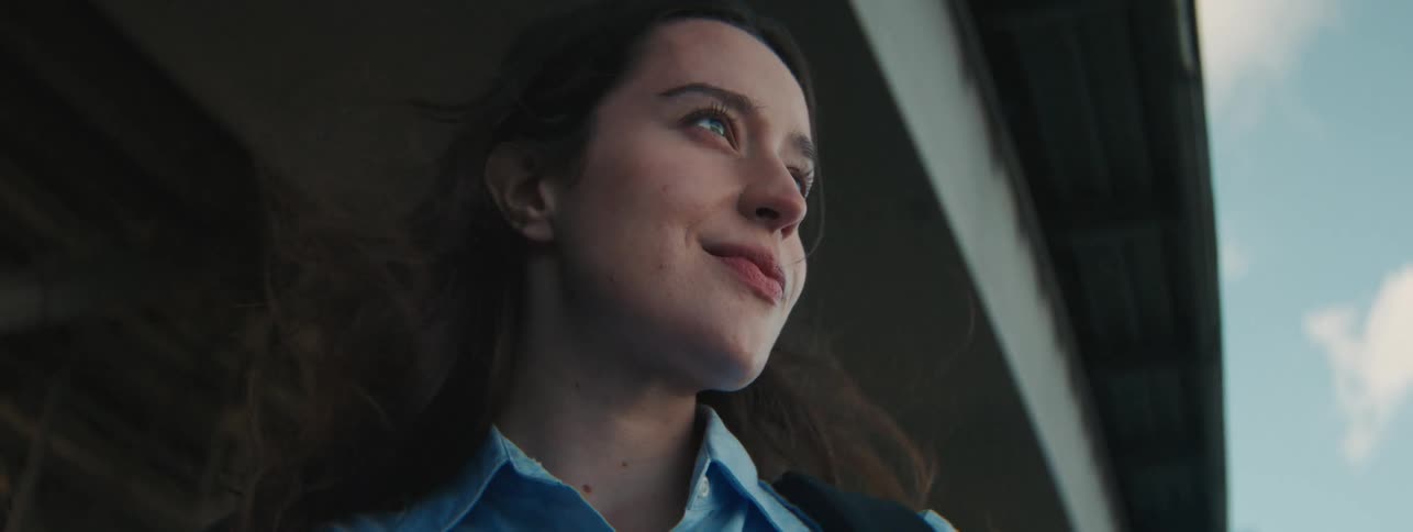 A woman standing under a bridge smiling
