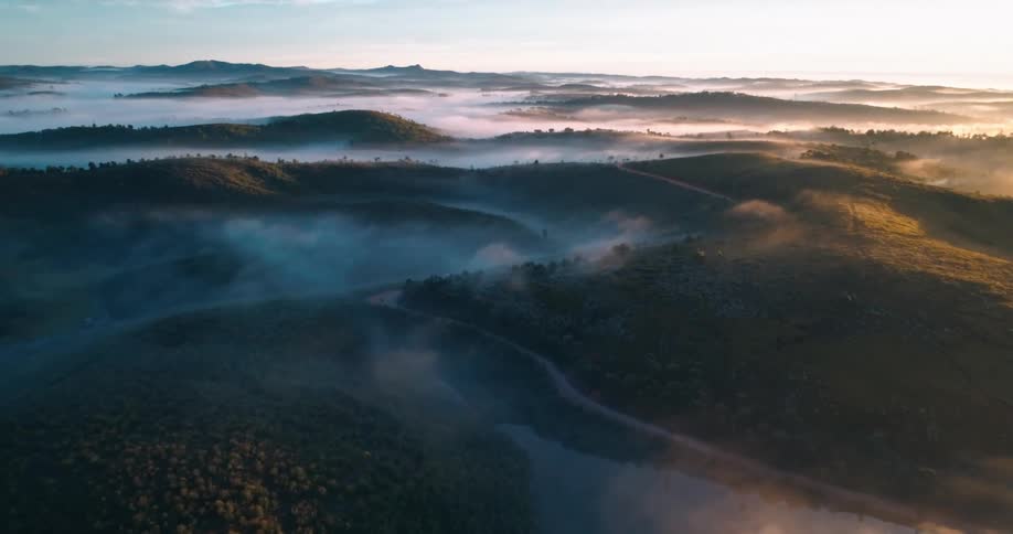 Aerial panorama of a landscape of greenish lakes and mountains with forests in a morning sky