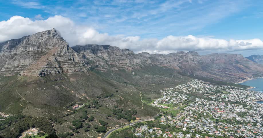 Clouds passing over coastal neighborhoods bordering the mountains cast shadows