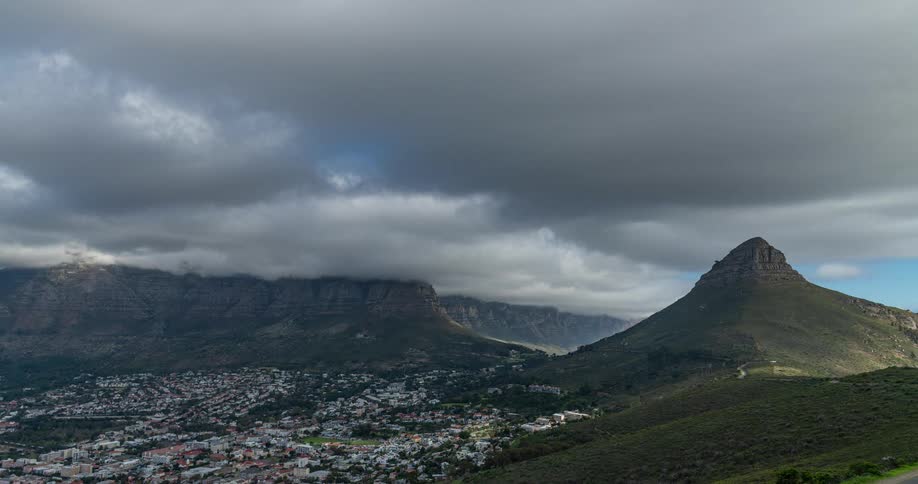 Clouds cast shadows as they pass over residential neighborhoods near the mountains