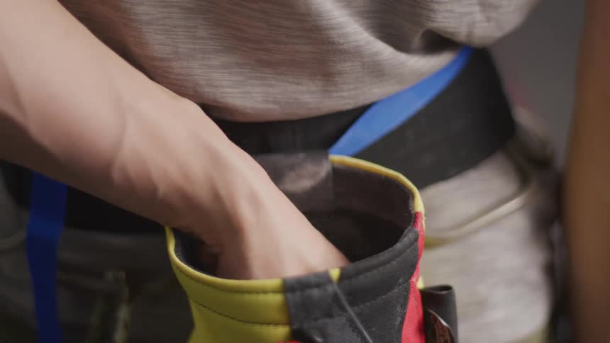 A persons hand being placed inside a pocket on a seat belt