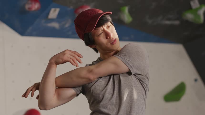 Man in indoor space stretching his arms
