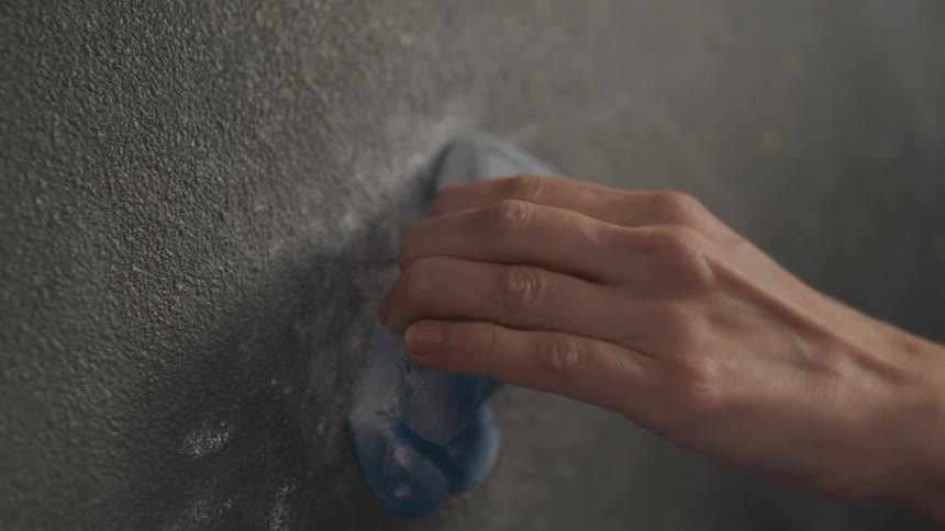 A man's hand holding gripping a hold on a training climbing wall