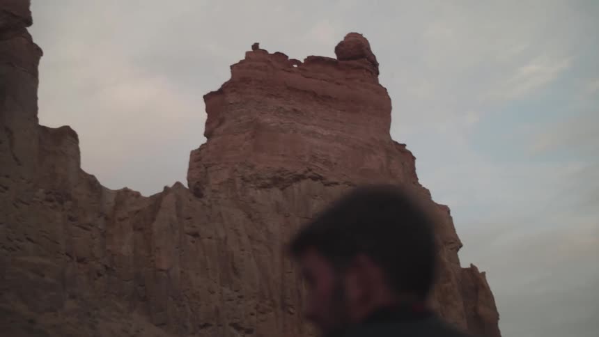 Back view of a man walking in a natural environment like canyons around