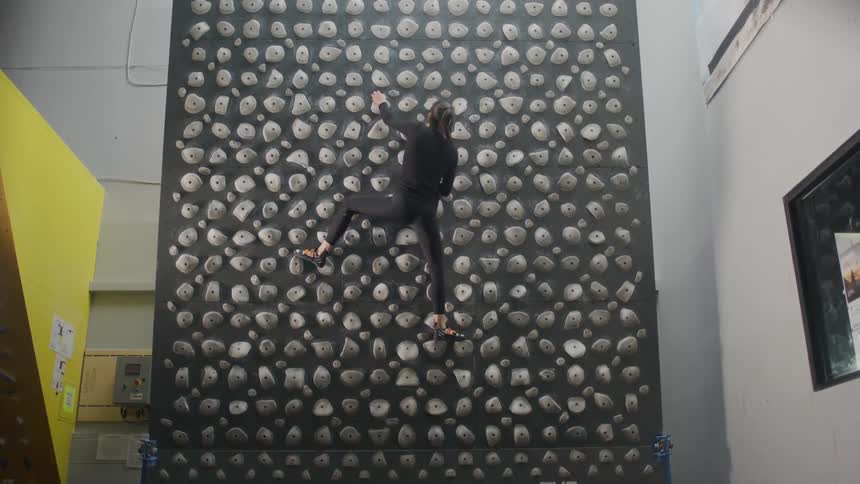 Woman training on a kilter board climbing wall