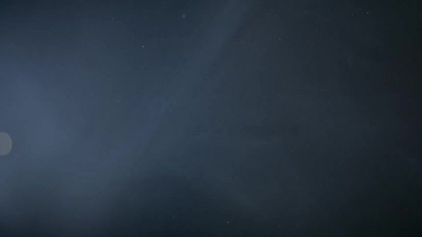 Small whitish balls falling in slow and abstract motion on a dark background