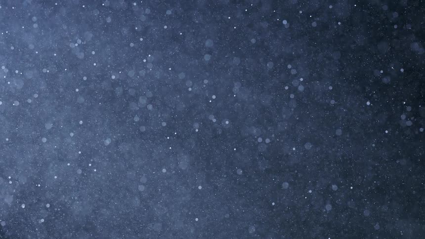 Snow falls outdoors at night