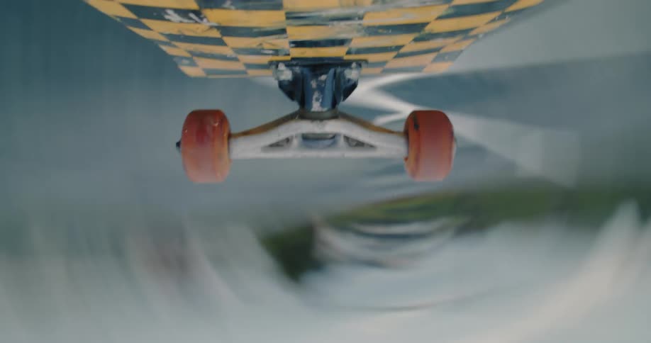 Point of view of a camera below a skateboard spinning in a trick