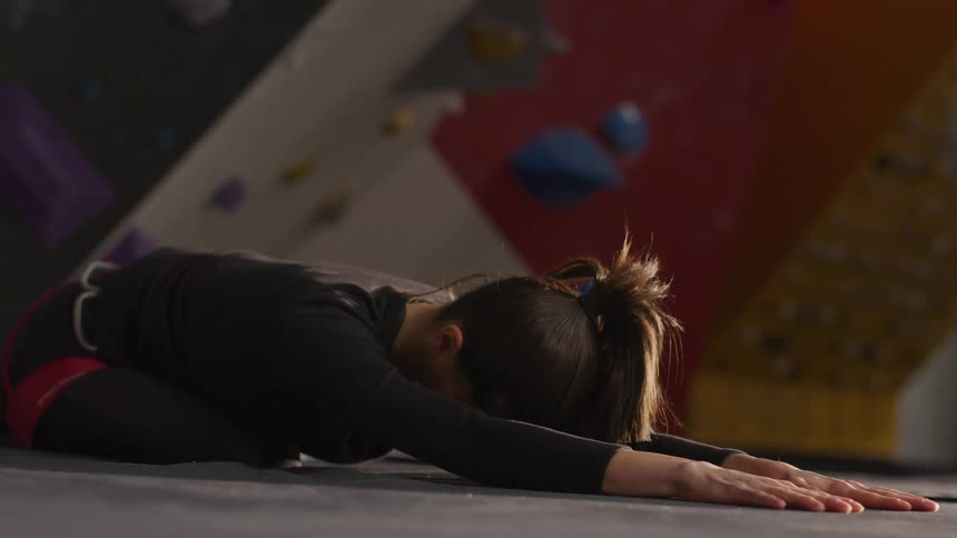 A woman is stretching in the gym