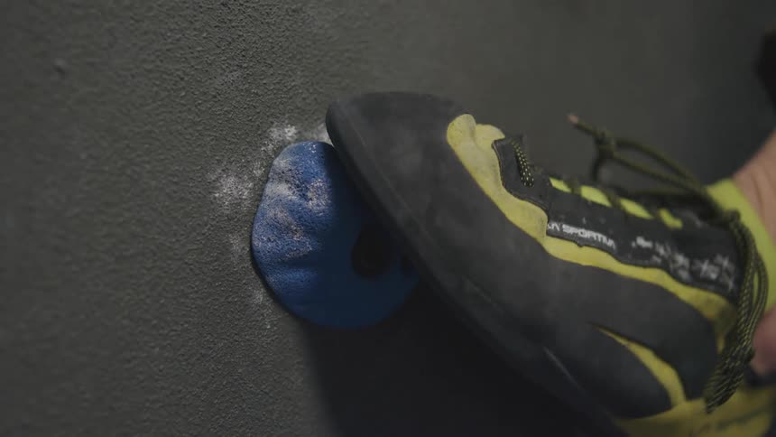 A person's foot finding a hold while training on a climbing wall
