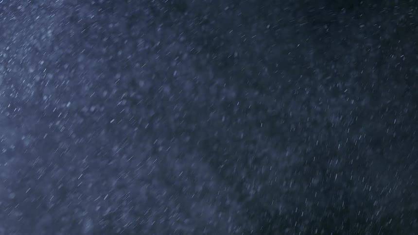 A lot of flecks of dust blowing in the wind at night