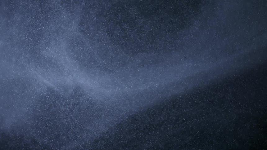 A cloud of small particulates drift slowly through the air to the left