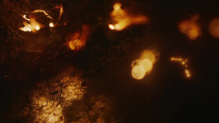 A surface of several wires is burning and many orange lights are coming out