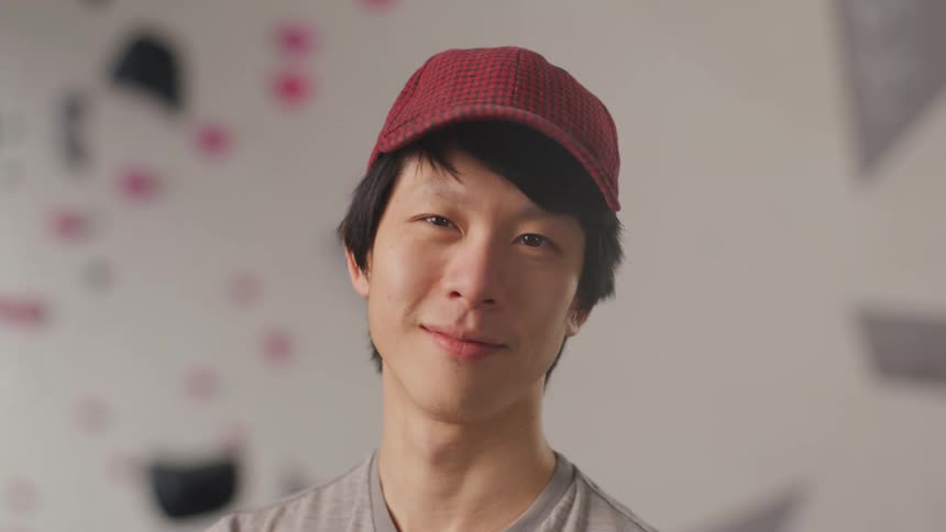 Portrait of a young asian man in a red cap giving a smile