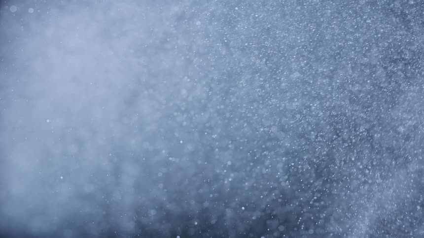 Several white particles moving on a black background