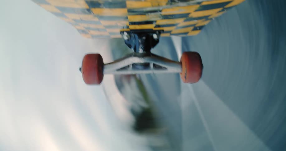 Point of view from a camera below a skateboard that is spinning in a trick