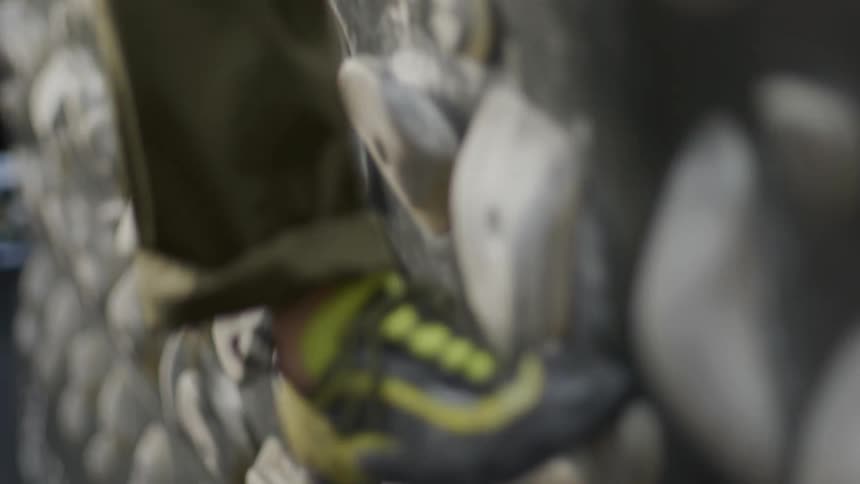 Legs and feet of a person training on a climbing wall