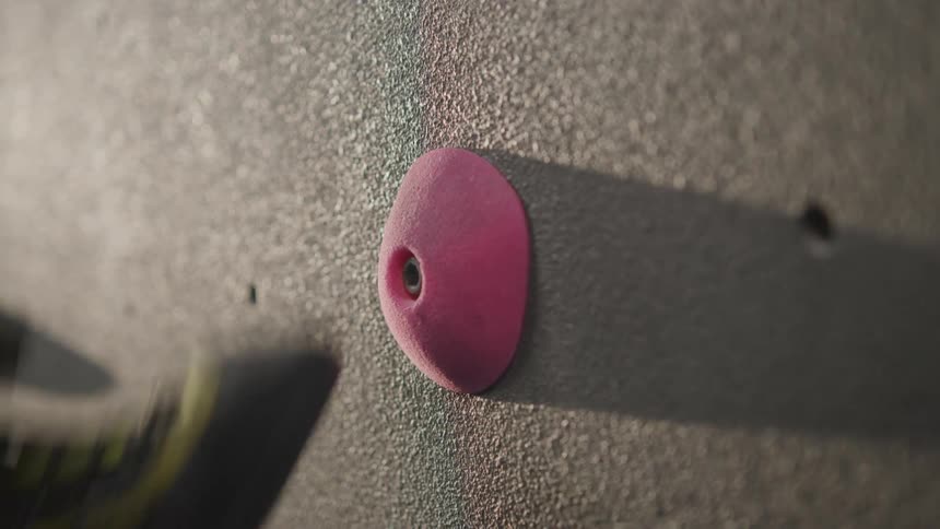 A person's foot finding a support hold on a climbing training wall