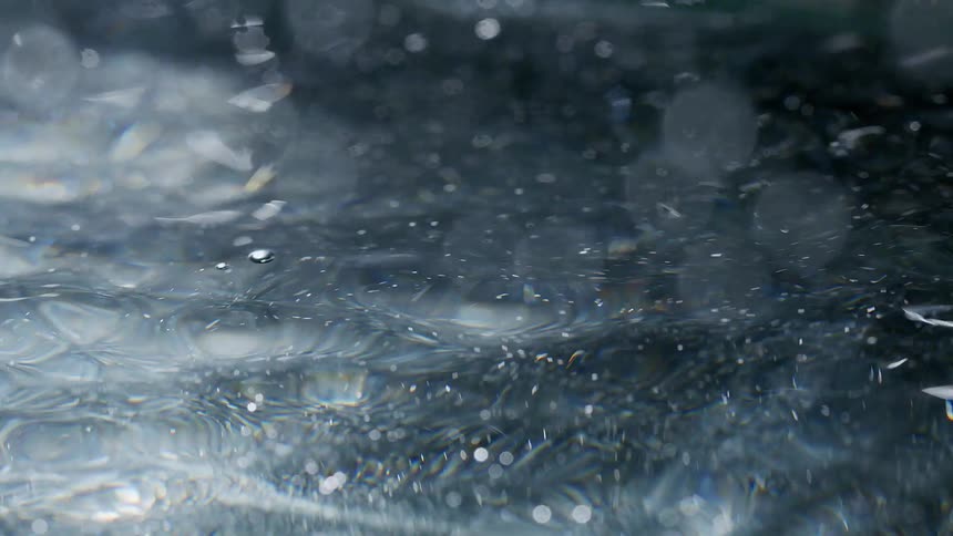 A moving water surface with many lights reflecting off the liquid