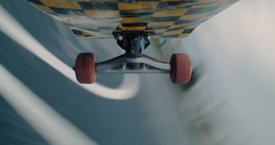 Point of view of the underside of a skateboard spinning in a trick