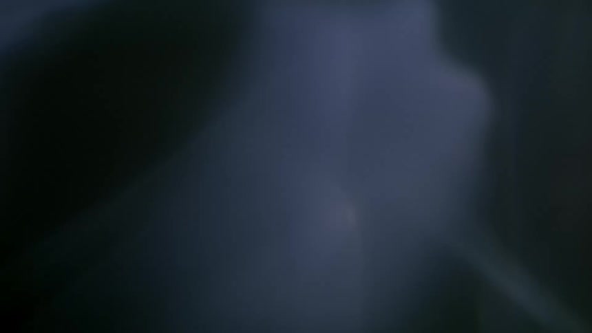 Extreme closeup on a light reflection on black background in slow motion