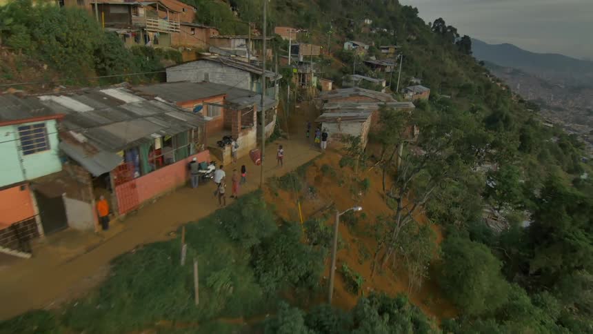 Kids run on the dirt street of a slum in the mountains