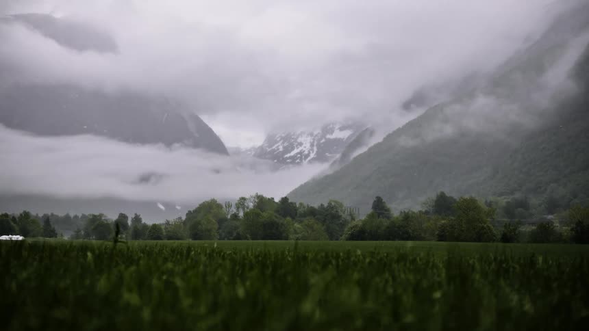 Low lying clouds obscure mountains near agricultural land