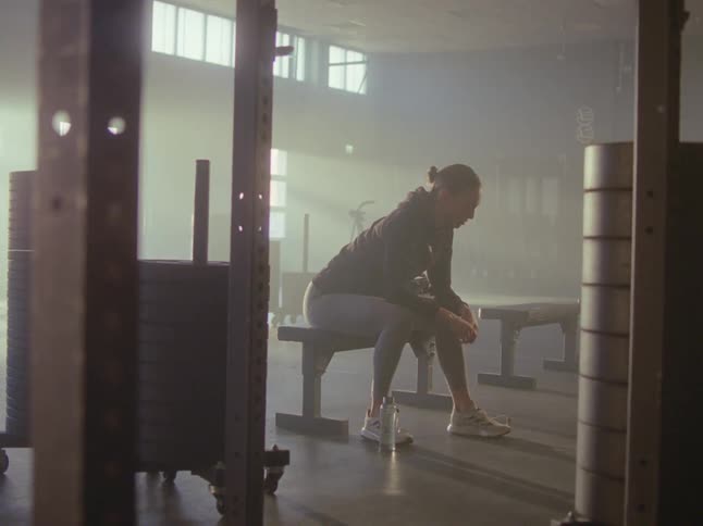 Woman sitting on a gym bench