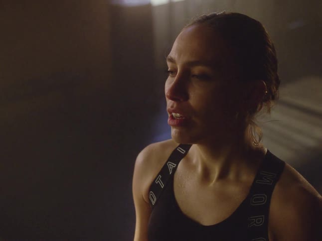 Portrait shot of a woman taking a deep breath and smiling after a workout