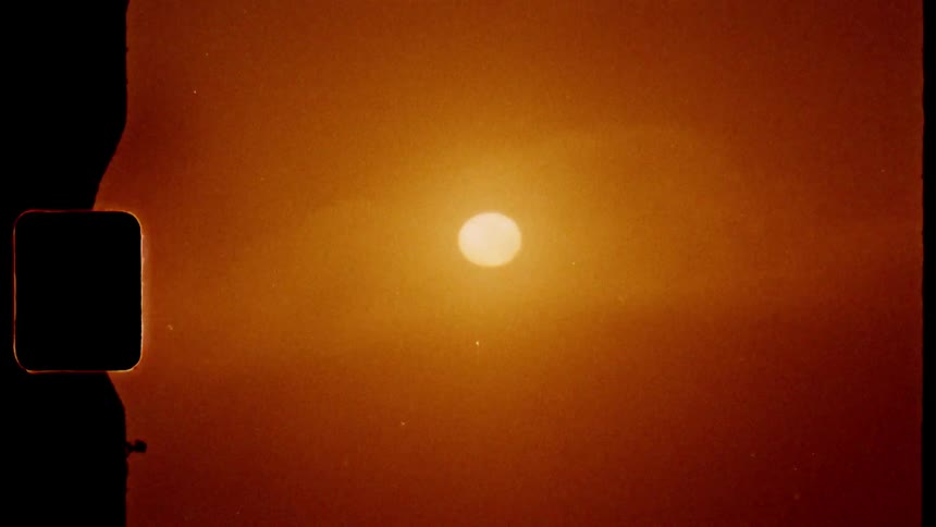 Zoom in on an orange sun on the horizon