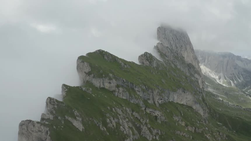 Aerial scenery of mountains with rocks on cliffs at cloud level during daytime