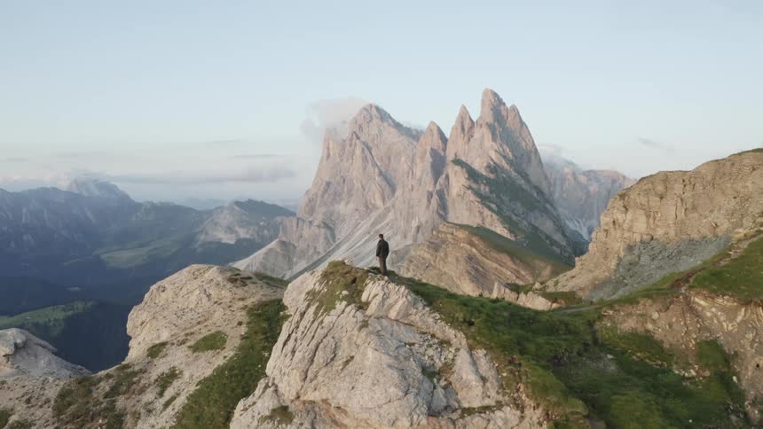 Man on the cliff of a rocky mountain one morning